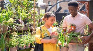Two customers carrying plants in pots